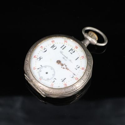 une montre de poche posée sur une surface noire