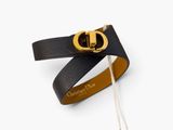 the black leather bracelet has a gold buckle on it