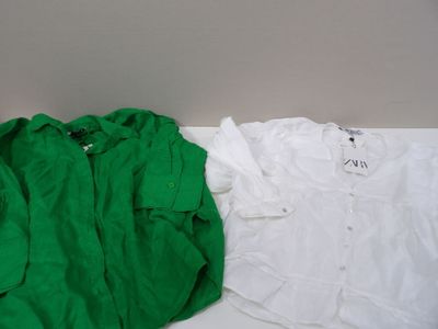 two white and green shirts sitting next to each other on a table