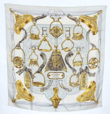 an image of a white and gold scarf with a picture of a clock and other items