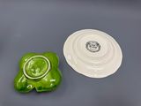 a green and white plate and a white plate on a table