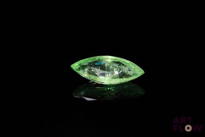 gros plan d'un diamant vert sur une surface noire