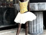 a statue of a little girl in a tutu on a wooden base