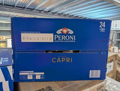Des cartons de Capri sont empilés les uns sur les autres dans un entrepôt