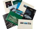 Diverses brochures de vente automobile sont empilées les unes sur les autres