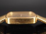 an image of a close up of a gold watch on a black surface