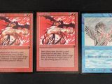 three cards with different designs on them on a black surface