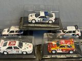 quatre modèles réduits de voitures dans une vitrine posée sur une table