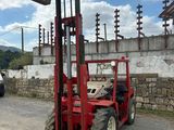 a red fork lift truck parked on the side of the road