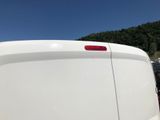 a white van parked in a parking lot with a mountain in the background