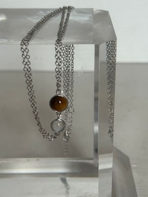 une chaîne en argent avec un pendentif en œil-de-tigre