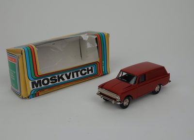 a red toy truck next to a box of moskvichtch