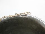 a large metal pot with a chain around it