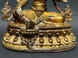 a gold statue of a person sitting on a table