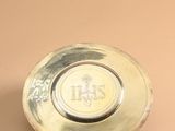 a small silver plate with a logo on it