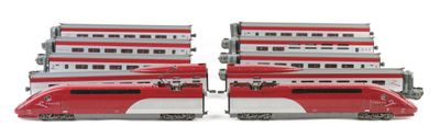 two red and white trains sitting side by side on a white surface
