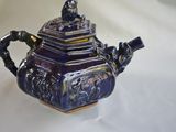 a blue and white teapot sitting on a white table