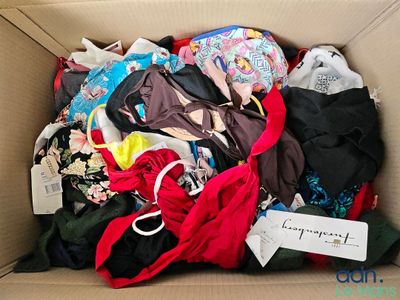 a cardboard box filled with lots of clothing and a tag