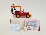 a red toy tractor with a sign attached to it