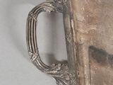 a silver plate with a handle on it on a table
