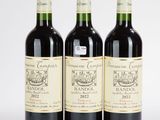 trois bouteilles de vin sont alignées sur une surface blanche