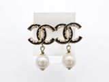 une paire de boucles d'oreilles pendantes ornées de perles et de perles noires et blanches