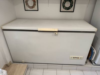 an image of a white refrigerator in a small room