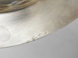 a silver plate with a silver handle on a table