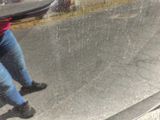 a person sitting on a bench in the rain with a skateboard