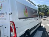 a white van parked in a parking lot with trees in the background