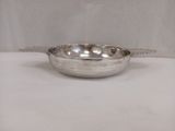 une assiette en argent avec une cuillère dessus, posée sur une table