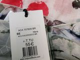 a label on the back of a dress with red flowers on it