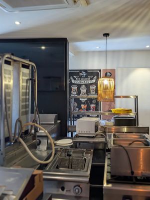 une photo de la cuisine d'un restaurant avec beaucoup de plats sur le comptoir