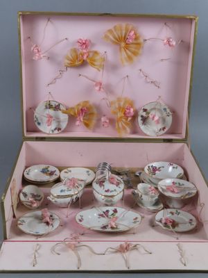 une boîte rose contenant un service à thé composé de tasses et de soucoupes