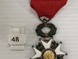 une image représentant une médaille ornée d'un ruban rouge et d'une étoile