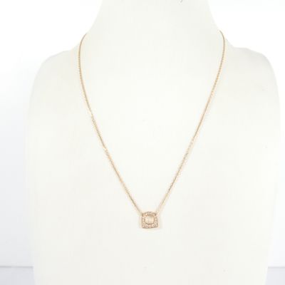 a gold necklace with a diamond initial pendant on a mannequin neck