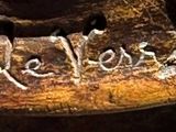 a close up of a piece of wood with writing on it