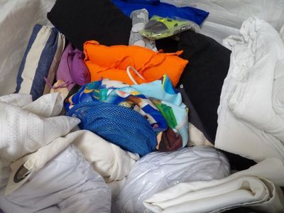 une pile de vêtements posée sur un lit