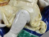 a figurine of a child sitting on a blue and white plate