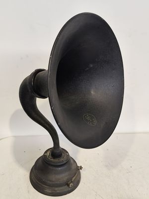 un vieux gramophone noir posé sur une surface blanche