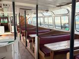 une vue de l'intérieur d'un bus avec des tables et des banquettes