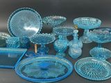 a lot of blue glass dishes and plates on the table