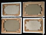 four pieces of cardboard are placed on a black surface
