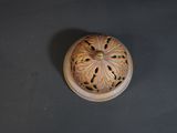 an overhead view of a wooden incense burner on a black surface