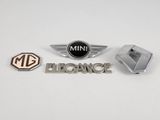 Trois emblèmes automobiles différents sont représentés sur un fond blanc