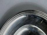 a silver plate with a silver rim on a gray surface