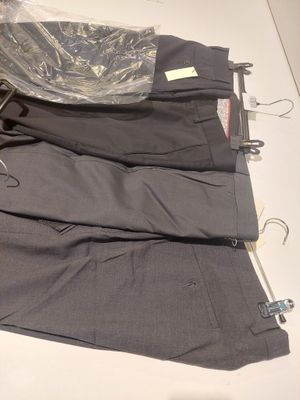 three pairs of pants sitting on a table next to a pair of scissors