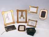 a group of small picture frames and a mirror on a table