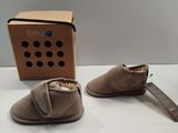 pair of baby shoes and a box on a white surface