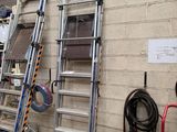 several ladders are lined up against a wall in a garage